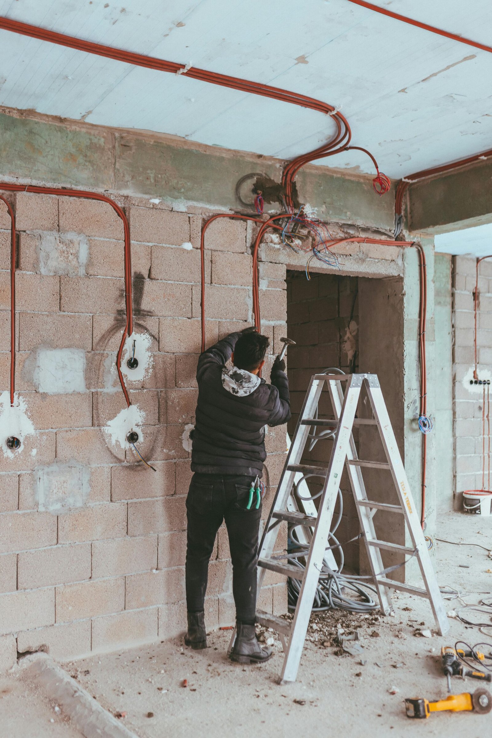 Electrician installing wiring during building renovation in Türkiye.